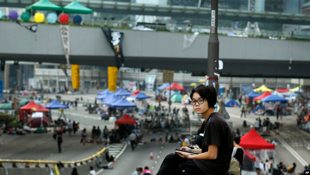 Seorang siswa pro-demokrasi menginap di jalan tempat demo berlangsung di Hong Kong, Minggu, 5 Oktober 2014.