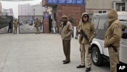 Indian police officers stand outside the district court where five men accused in a gang rape were brought to appear in New Delhi, January 7, 2013. 