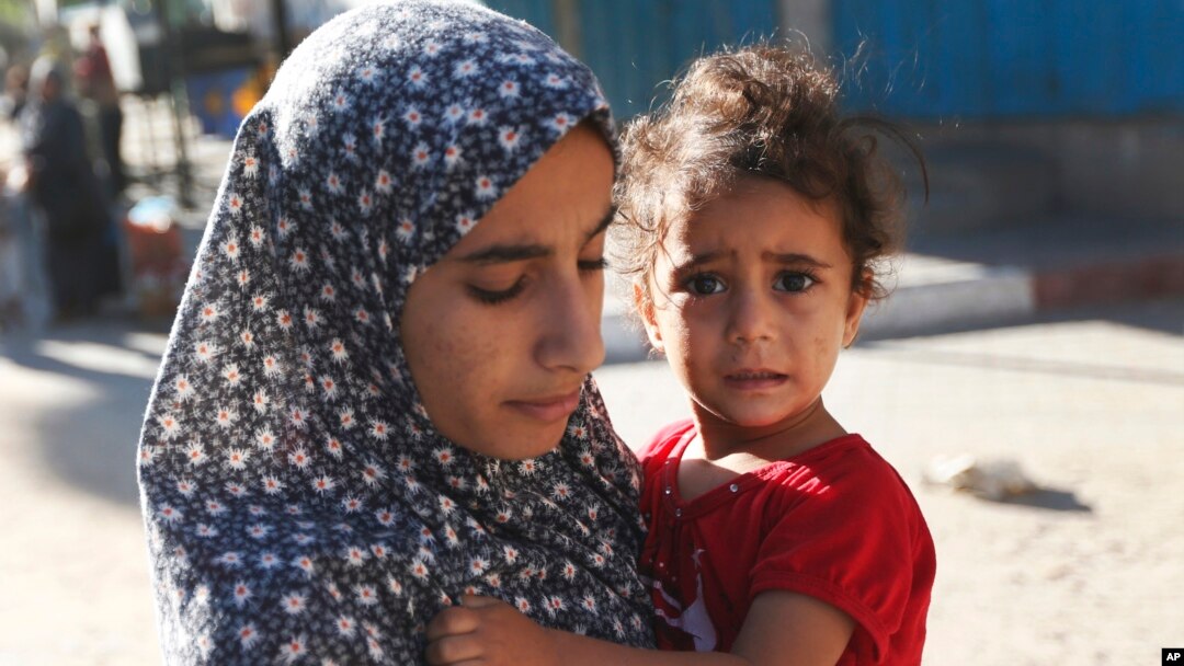 Người dân ở khu Shajaiyeh, thành phố Gaza, bỏ nhà cửa chạy trốn sau khi Israel thả tờ rơi cảnh báo người dân rời khỏi khu vực, 16/7/2014. 