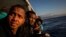 FILE - Nigerian men who were rescued off the Libyan coast on Friday, watch the sea from the deck of the Open Arms rescue vessel as the ship approaches the port of Messina, Italy, Jan. 15, 2020. 