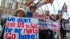 FILE - Protesters holding anti-American signs are seen gathered in front of the U.S. Embassy at a rally against what they see as American mingling in Russia's internal affairs, in Moscow, Russia, March 7, 2015.