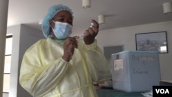 A health official at Wilkins Hospital in Harare, Zimbabwe, prepares to inoculate with Sinopharm vaccine, March 11, 2021. (Columbus Mavhunga/VOA)