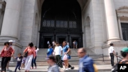 People walk outside of the American Museum of Natural History in New York, July 18, 2024