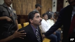 Former special forces soldier Carlos Antonio Carias, center, gestures to his lawyer after being sentenced at the end of his trial in Guatemala City, Tuesday, Aug. 2, 2011