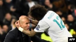 Le défenseur brésilien du Real Madrid Marcelo, à droite, célèbre un but avec Zinedine Zidane, l'entraîneur français du club lors du match aller contre le Paris Saint-Germain (PSG), en UEFA Champions League, au stade Santiago Bernabeu de Madrid, le 14 février 2018.