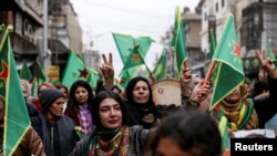 Sejumlah perempuan membawa bendera Unit Perlindungan Perempuan (YPJ) dalam demo menuntut penguasa baru Suriah untuk menghormati hak-hak perempuan, di Kota Qamishli, Suriah, 23 Desember 2024. (Foto: Orhan Qereman/Reuters)