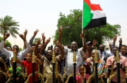 FILE - Sudanese people celebrate the signing of a constitutional declaration between the deputy head of the Sudanese Transitional Military Council, Mohamed Hamdan Dagalo, and opposition alliance leader Ahmad al-Rabiah, in Khartoum, Aug. 4, 2019.