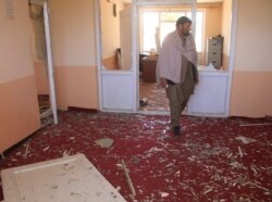 An Afghan man inspects at the site of a blast in Ghazni province, May 18, 2020.