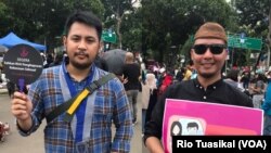 Christian Patricho Adoe dari Gerakan Mahasiswa Kristen Indonesia (GMKI) dan Andre Flo dari Gusdurian Jakarta mengikuti pawai untuk mendesak pengesahan RUU Penghapusan Kekerasan Seksual (P-KS), Jakarta, Sabtu, 8 Desember 2018. (Foto: Rio Tuasikal/VOA)