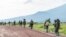 FILE - M23 rebels walk on a road as they leave after a ceremony to mark the withdrawal from their positions in the town of Kibumba, in the eastern of Democratic Republic of Congo, Friday, Dec. 23, 2022.
