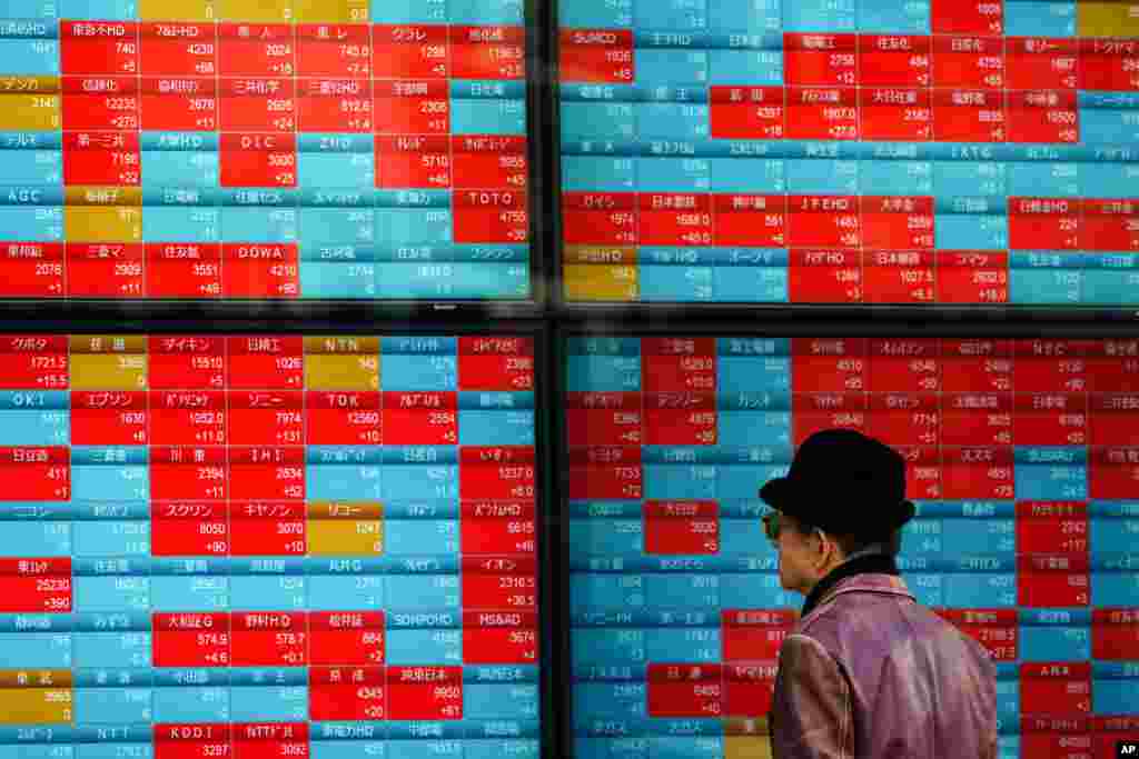 A man looks at an electronic stock board showing Japan&#39;s Nikkei 225 index at a securities firm in Tokyo.