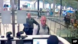 FILE - Michael Taylor, center, is seen at passport control at Istanbul Airport in Turkey, Dec. 30, 2019, in this image from security camera video.
