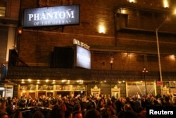 People gather outside the Majestic Theatre after the final performance of the Phantom of the Opera, which closes after 35 years on Broadway, in New York, April 16, 2023.