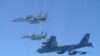 资料照片：这张由日本防卫省提供的照片显示，日本航空自卫队的F-15战斗机在日本领空附近与美国B-52轰炸机进行了联合军事演习。(2025年12月10日)