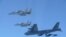 资料照片：这张由日本防卫省提供的照片显示，日本航空自卫队的F-15战斗机在日本领空附近与美国B-52轰炸机进行了联合军事演习。(2025年12月10日)