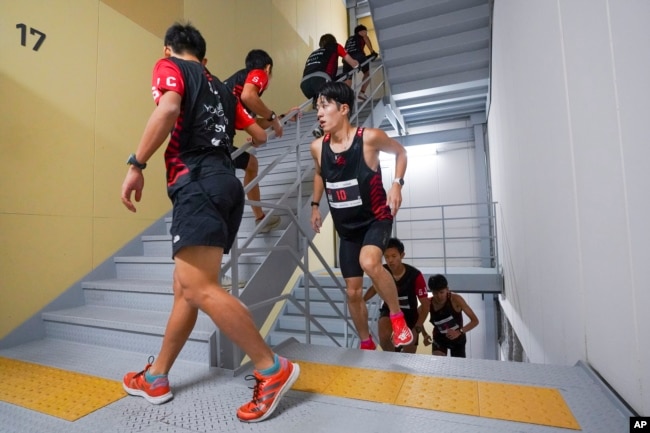 FILE - In this photo provided by ISF/Meeting, competitors climb stairs during a race of Stairclimbing World Championships in Osaka, western Japan, on Nov. 19, 2023. (ISF/MEETING via AP)