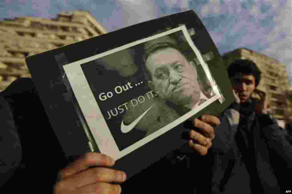 A protester holds a placard showing Egyptian President Hosni Mubarak and reading "Go out... Just do it" at the continuing anti-government demonstration in Tahrir Square in downtown Cairo, Egypt Thursday, Feb 10, 2011. (AP Photo/Ben Curtis)