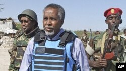 Somali Interior Minister Abdi Shakur Sheik Hassan, center, is escorted by soldiers in Mogadishu, February 23, 2011