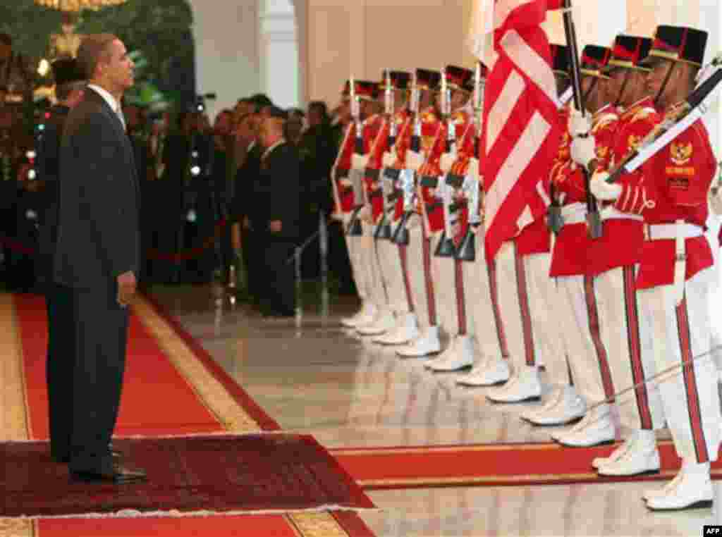 U.S. President Barack Obama, left, accompanied by Indonesian President Susilo Bambang Yudhoyono, partially seen behind Obama, stand for the playing of the national anthems at the Presidential Palace in Jakarta, Indonesia on Tuesday November 9, 2010. (AP P