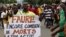 FILE - A man holds up a sign, which reads: "Faure still how many death by you," during an opposition protest calling for the immediate resignation of President Faure Gnassingbe in Lome, Togo, Sept. 6, 2017. 