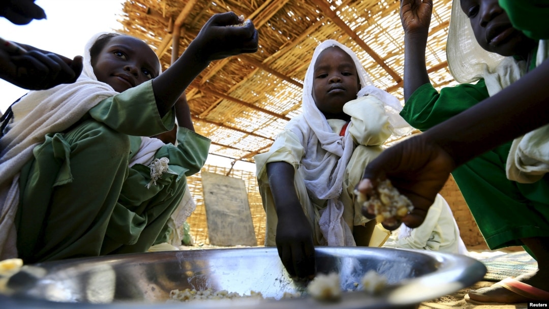 Pengungsi anak-anak usia sekolah makan dari mangkuk yang sama di kamp Abushouk di Al Fasher, Darfur Utara, Sudan, 17 Nov 2015.