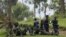 M23 rebel fighters watch the venue of a news conference by political leader Jean-Marie Runiga, in Bunagana, eastern DRC, in north Kivu province, July 21, 2012.