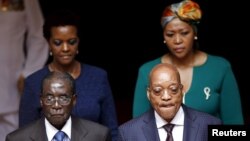 Zimbabwe's President Robert Mugabe, front left, and South Africa's President Jacob Zuma, front right, enter the Union building in Pretoria, April 8, 2015. Also pictured are Zimbabwe's first lady Grace Mugabe, rear left, and South Africa's first lady Thobe