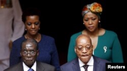 Zimbabwe's President Robert Mugabe, front left, and South Africa's President Jacob Zuma, front right, enter the Union building in Pretoria, April 8, 2015. Also pictured are Zimbabwe's first lady Grace Mugabe, rear left, and South Africa's first lady Thobe