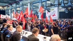 Employees protest before the start of a works meeting in a hall at the VW plant in Wolfsburg, Sept. 4, 2024. Volkswagen has announced that it will tighten its austerity measures due to the tense situation of the core brand.