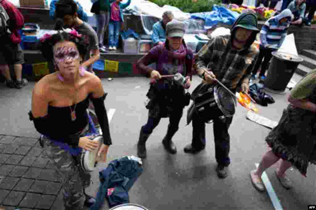 Occupy Wall Street protestors play drums and sing songs in the financial district's Zuccotti park Sunday, Oct. 2, 2011, in New York. The protests have gathered momentum and gained participants in recent days as news of mass arrests and a coordinated media