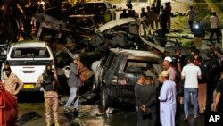 FILE - Security officials work on the site of an explosion that caused injures and destroyed vehicles outside the Karachi airport, Pakistan, Oct. 7, 2024. Pakistani Baloch separatists claim deadly bomb attack that killed 2 Chinese near Karachi airport.