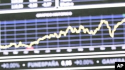 Traders look at a stock index board at Madrid's stock exchange, January 16, 2012