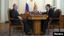 Russian President Vladimir Putin (L) meets with Prime Minister Dmitry Medvedev at the Novo-Ogaryovo state residence outside Moscow, March 27, 2014.