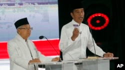 Indonesian President Joko Widodo, right, delivers a speech with running mate Ma'ruf Amin during a televised presidential candidates debate in Jakarta, Indonesia, April 13, 2019. 