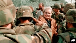 FILE - Secretary of State Madeleine Albright greets US Soldiers at Bondsteel camp near Urosevac, some 35 kms. south of Pristina, July 29, 1999.