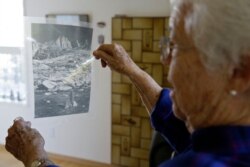 Joan Busby looks at a transparency of where her mother found human remains in 1945 of Giichi Matsumura on Mount Williamson, at her home in Mill Valley, Calif., Oct. 22, 2019.