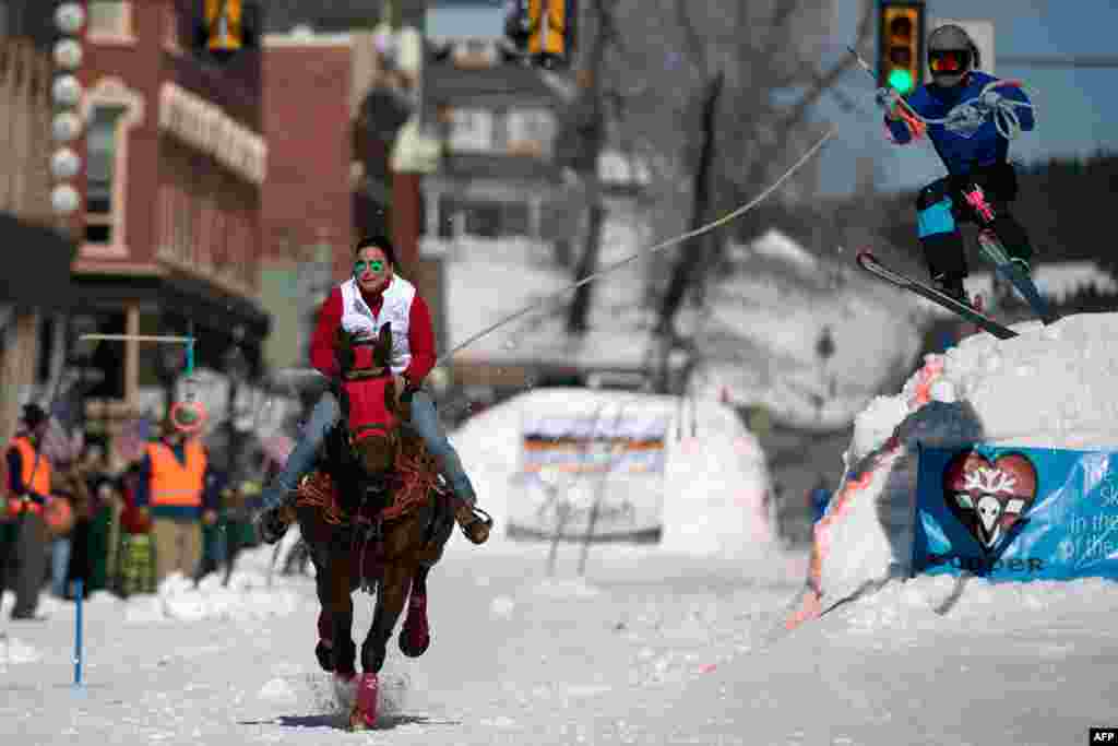 Rider Kelley McComb races down Harrison Avenue while skier Shaun Gerber airs out off the first jump of the Leadville ski joring course during the 72nd annual Leadville Ski Joring weekend competition in Leadville, Colorado, March 7, 2020.