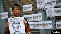A woman holds a poster of Simon Cheng, a staff member at the British consulate, during a protest outside the British Consulate-general office in Hong Kong, Aug. 21, 2019. 