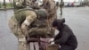 俄罗斯国防部2022年5月19日公布的视频截图显示俄罗斯军人在乌东顿涅茨克亲俄政权控制区检查离开马里乌波尔亚速钢铁厂的乌克兰军人的随身物品。