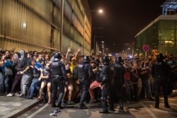 FILE - Police charge against demonstrators during clashes outside El Prat airport in Barcelona, Spain, Oct. 14, 2019.