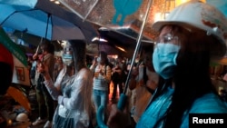 Pro-democracy protesters stand in heavy rain while blocking a main road at Mongkok shopping district in Hong Kong, October 22, 2014.