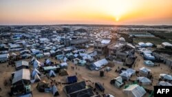 FILE - This aerial view shows the sun setting over Egypt across the border from the tent camps of displaced Palestinians in Rafah in the southern Gaza Strip on December 31, 2023.