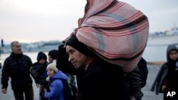 Pengungsi dan para migran ketika baru turun dari sebuah ferry di pelabuhan utama Athena, di Piraeus, 27 Januari 2016.