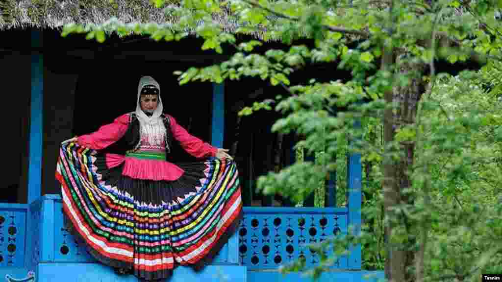 یک زن با لباس محلی در موزه میراث روستایی گیلان عکس یادگاری می گیرد. عکس: علی اسدالهی سوته، تسنیم