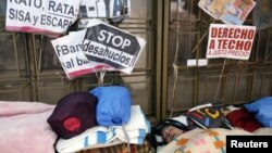People sleep outside the headquarters of Spanish nationalized lender Bankia, where protesters have camped for more than three weeks, in Madrid, November 20, 2012.