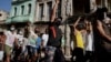 Cubanos gritan consignas durante protestas a favor y en contra de las gobierno, en medio del brote de la pandemia de COVID-19, en La Habana, Cuba, el 11 de julio de 2021. 