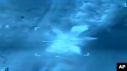 FILE - An image taken from aerial footage shows a target hit by an airstrike in Libya.