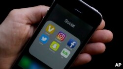 FILE - This June 16, 2017 photo shows social media app icons on a smartphone.