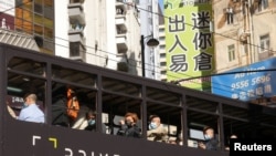 香港街頭，大眾帶著口罩乘坐電車。