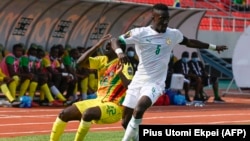 Le défenseur zimbabwéen Takudzwa Chimwemwe rivalise avec le milieu de terrain sénégalais Idrissa Gana Gueye lors du match de football du Groupe B de la Coupe d'Afrique des Nations (CAN) 2021 entre le Sénégal et le Zimbabwe au Stade de Kouekong à B